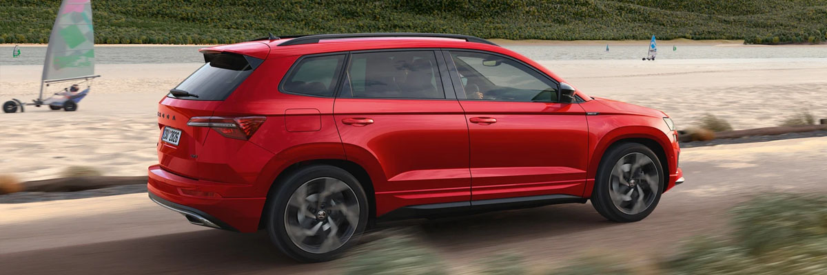 Rear and side view of an red Karoq driving