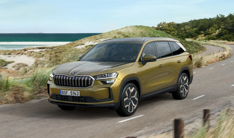A yellow Kodiaq driving by the beach